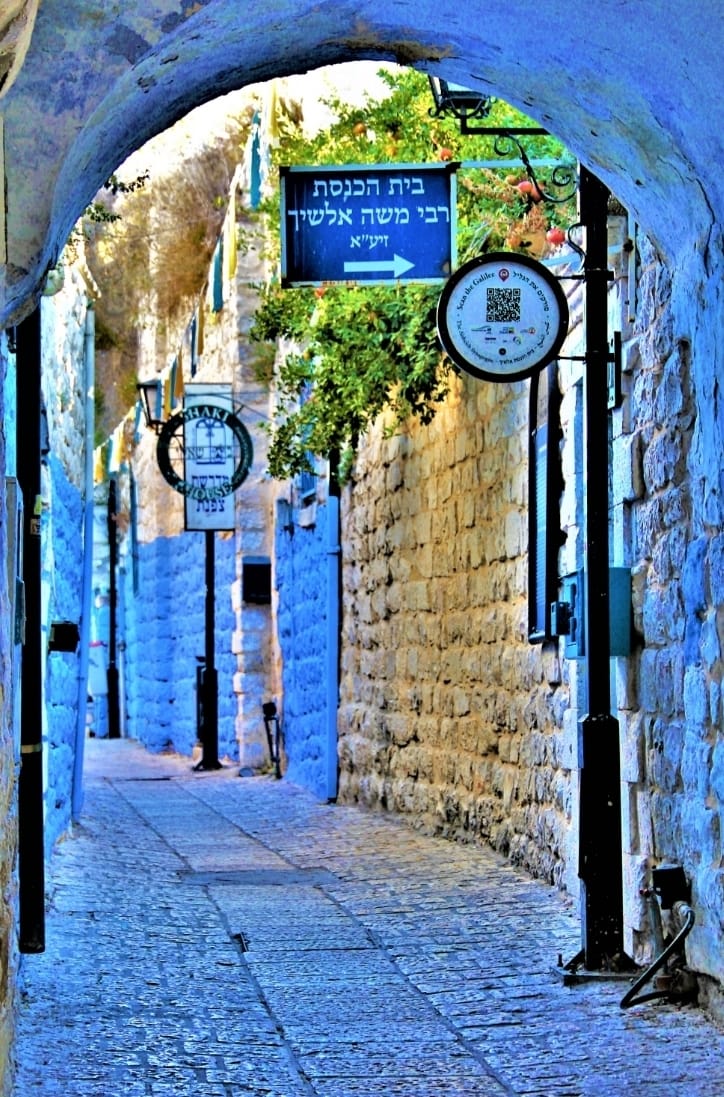 Arched alley in Old Safed with a sign pointing to the Rabbi Moshe Alshich Synagogue